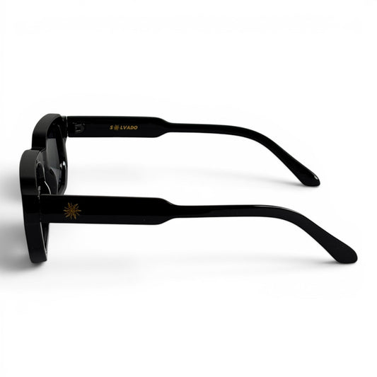 solvado Shadow Core Sonnenbrille in Schwarz mit goldenem Sonnen-Logo am Bügel, Seitenansicht auf weißem Hintergrund